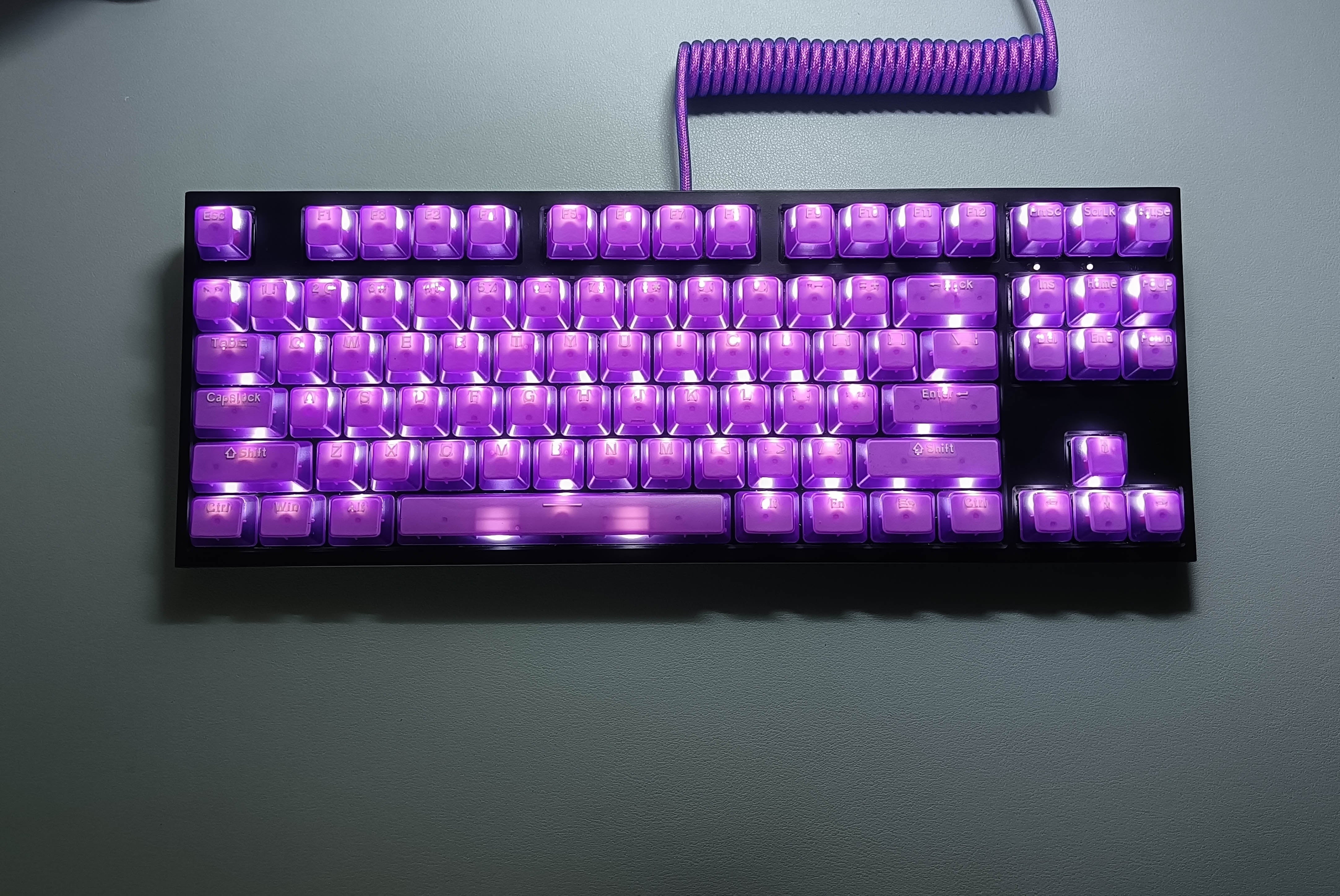 purple transparent keycaps set on a rgb lit black mechanical keyboard