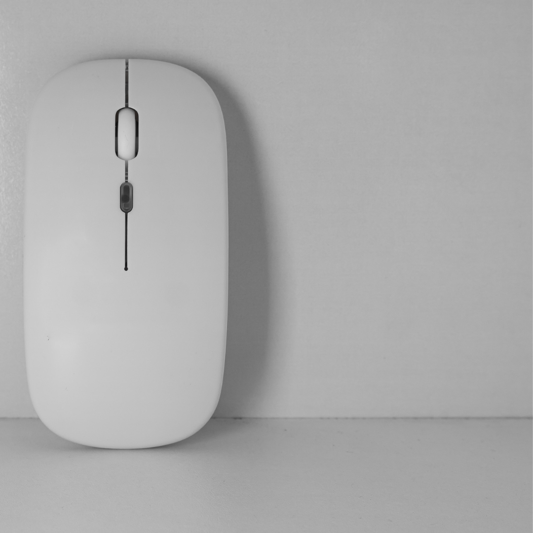 white bluetooth mouse standing up against a white wall