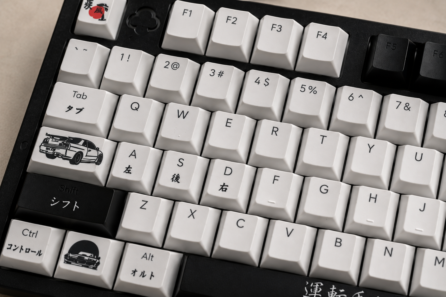 Close-up of a JDM aluminium custom keyboard with labeled keys on a beige surface